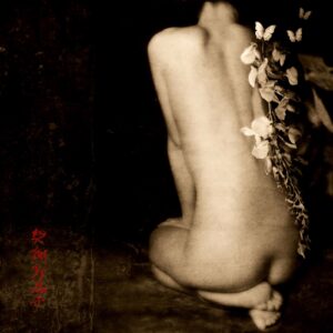 A nude woman sitting on the ground with flowers.