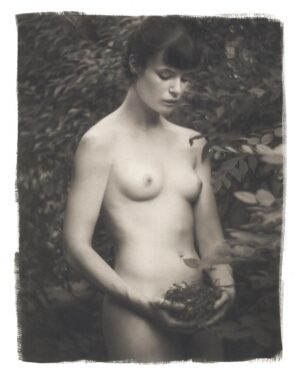 A woman holding a bunch of leaves in her hands.