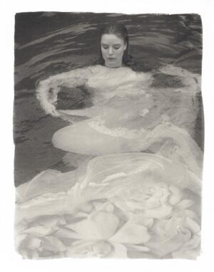 A woman in the water with her arms outstretched.