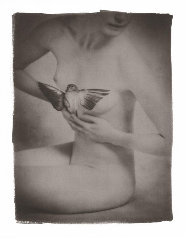 A woman holding her breast with one hand and another on the other.