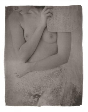 A woman in a white dress holding her hands on the chest.