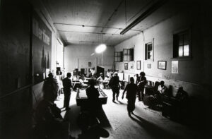 A group of people in a room with tables and chairs.