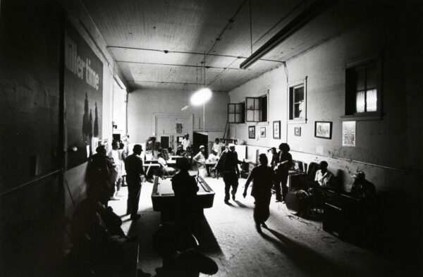 A group of people in a room with tables and chairs.