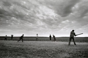 A group of people playing baseball in the field.