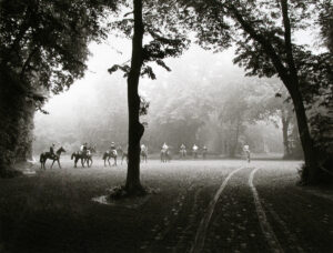 A group of people riding horses in the middle of a field.