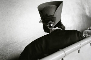 A black and white photo of a hat on top of a bench.