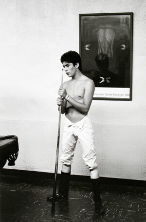 A young man holding a pool stick in his hands.