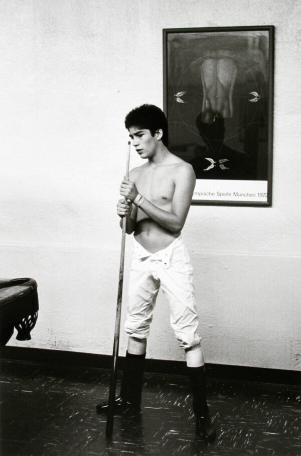 A young man holding a pool stick in his hands.