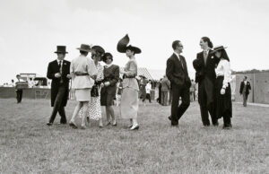 A group of people in hats and suits standing on top of a field.
