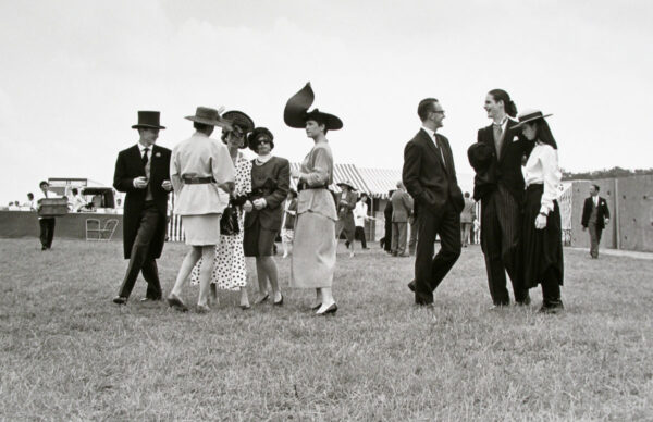 A group of people in hats and suits standing on top of a field.