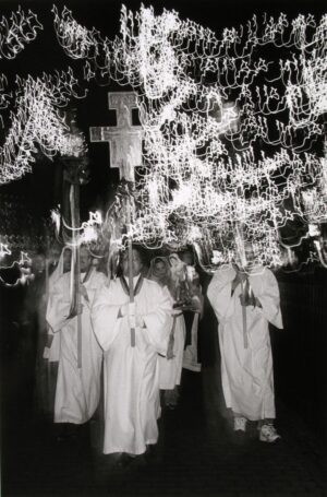 A group of people in white robes holding crosses.