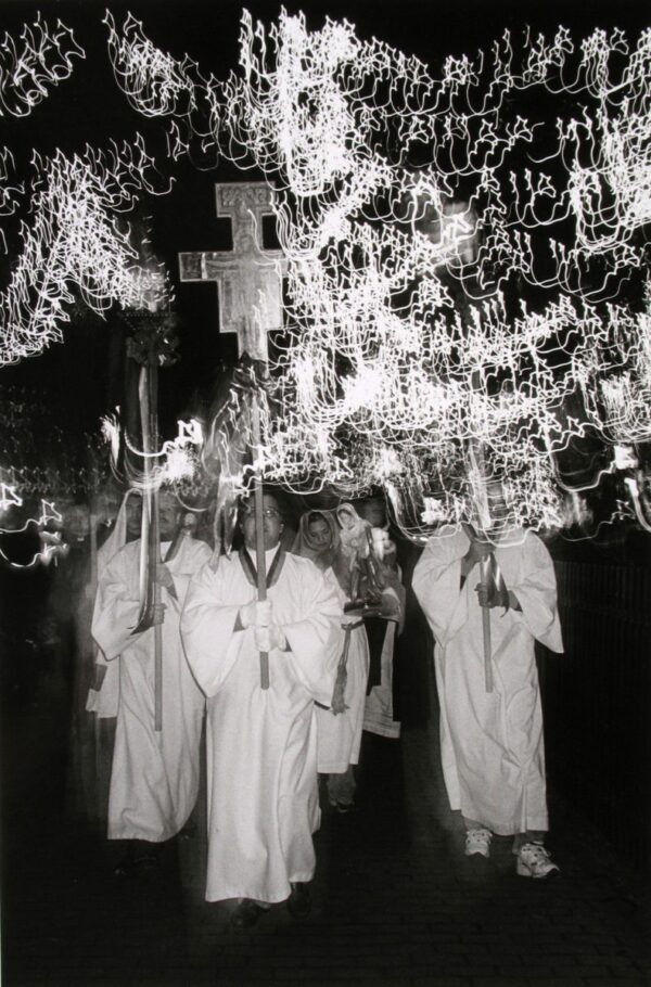 A group of people in white robes holding crosses.