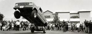 A truck is parked on the street in front of people.