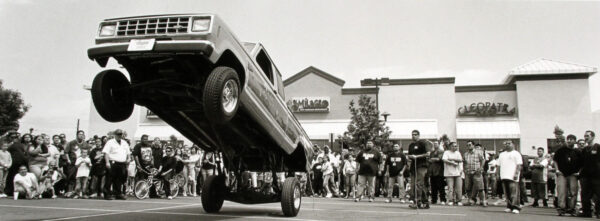 A truck is parked on the street in front of people.