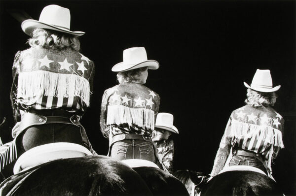 A group of people wearing cowboy hats and jackets.