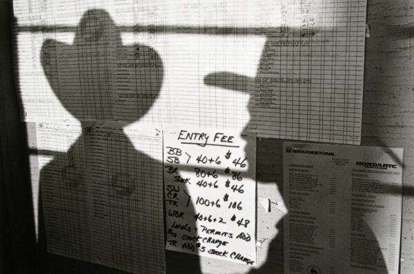 A person is standing in front of a window with papers on it.