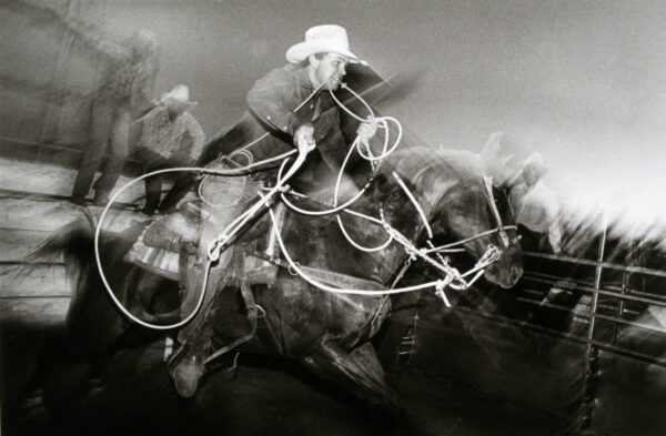 A blurry picture of horses and riders in motion.