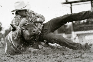 A man falling down on the ground while riding a horse.