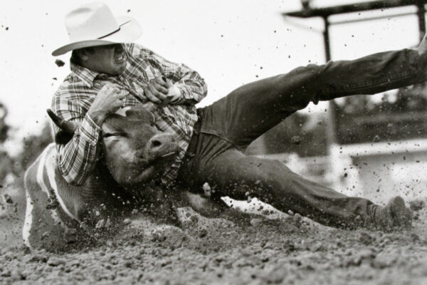 A man falling down on the ground while riding a horse.