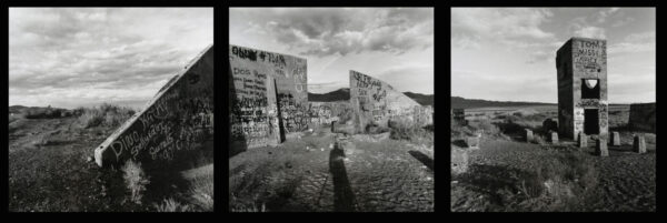 A black and white photo of graffiti on the side of a wall.