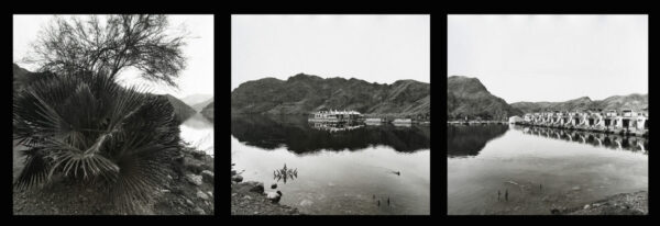 A black and white photo of a lake with boats.