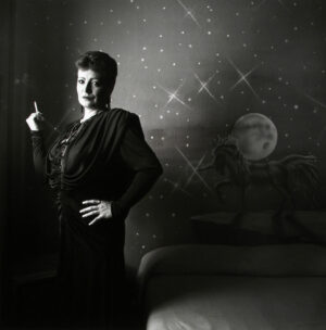 A woman standing in front of a wall with stars and moon.