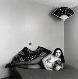 A woman laying on the bed with her cat.