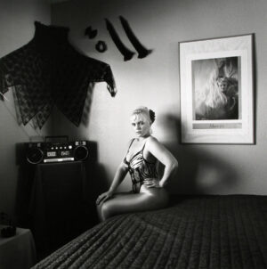 A woman sitting on top of a bed in her underwear.