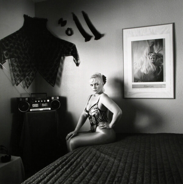 A woman sitting on top of a bed in her underwear.