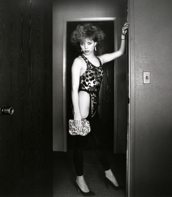A woman standing in front of a door.