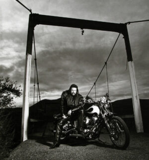 A man sitting on the back of his motorcycle.
