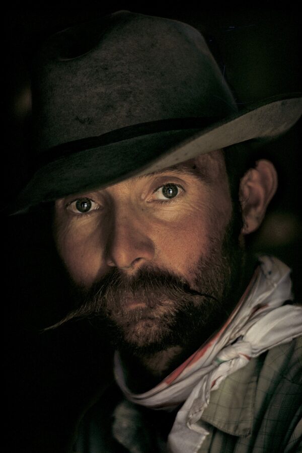 A man with a beard and mustache wearing a hat.