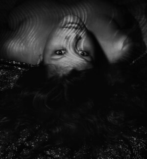 A woman laying on the ground with her head in the air.