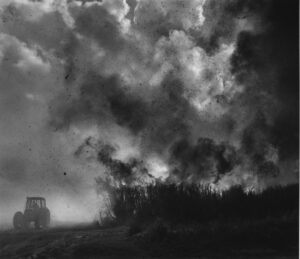 A black and white photo of smoke billowing from the ground.