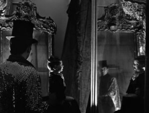A woman standing in front of a mirror with her cat.