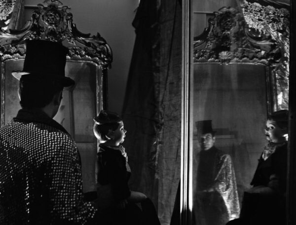 A woman standing in front of a mirror with her cat.