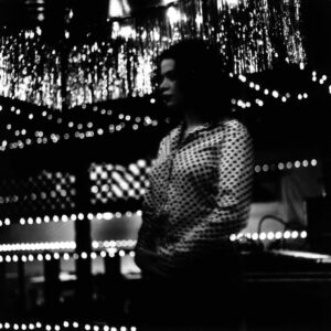 A woman standing in front of lights at night.