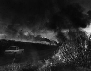 A car driving down the road with smoke coming from it.