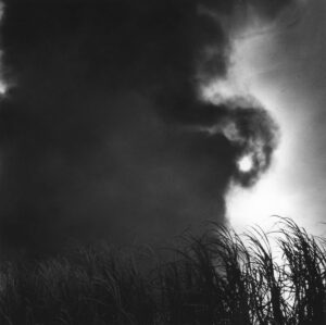 A black and white photo of smoke coming from the sky.