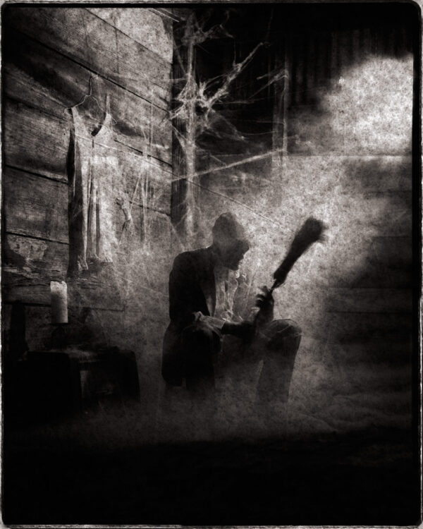 A man holding a guitar in the middle of an alley.