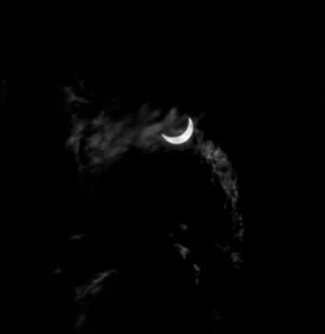 A black and white photo of the moon in the dark.