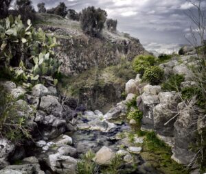 A painting of a stream in the middle of a rocky area.