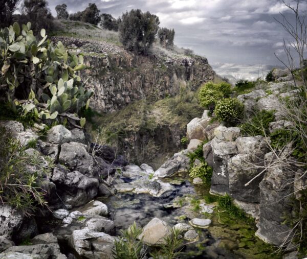 A painting of a stream in the middle of a rocky area.