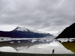 A person walking on the beach near some water
