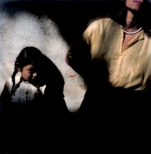 A woman and child standing in the dark.