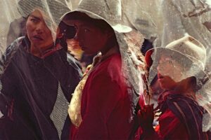 A group of people standing under an umbrella.