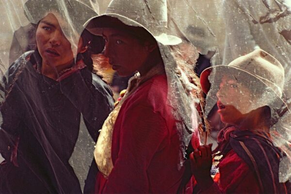 A group of people standing under an umbrella.
