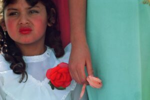 A girl with a rose in her hand and a person holding something