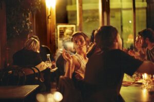A woman is sitting at the bar and looking in the mirror.