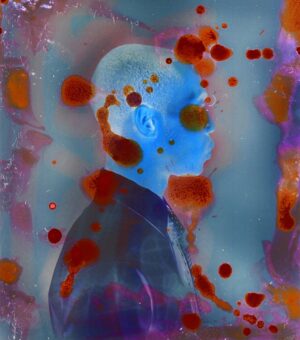 A man with blue eyes and red hair is standing in front of some blood.
